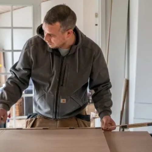 Erfaren tømrer i Vestsjælland måler og tilpasser materialer til professionelt tømrerarbejde