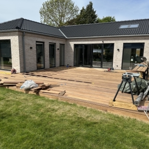 Tømrer udfører tømrerarbejde med renovering af træterrasse ved villa i Vestsjælland