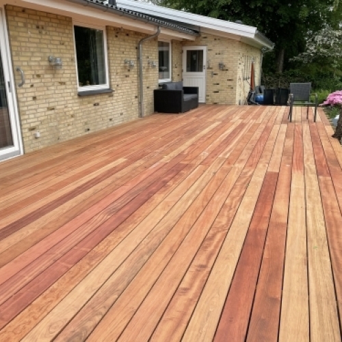 Tømrer udfører tømrerarbejde med stor træterrasse ved enfamiliehus