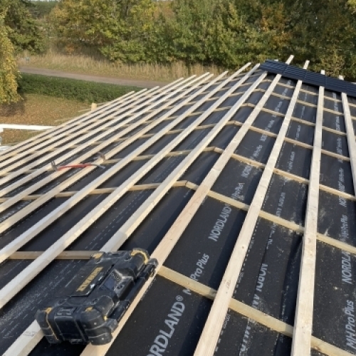 Tømrer udfører tømrerarbejde med opbygning af tag med lægter og undertag