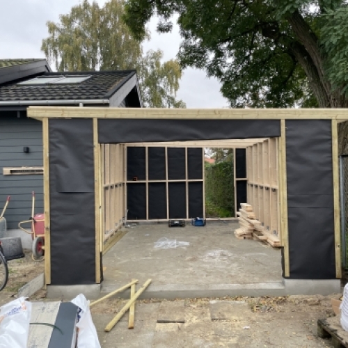 Tømrer udfører tømrerarbejde med opbygning af skelet til tilbygning i Vestsjælland