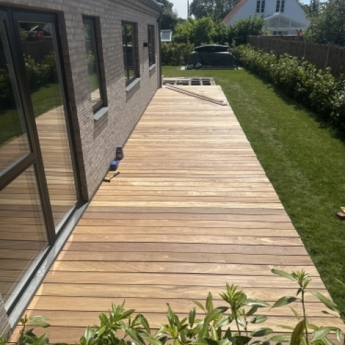 Tømrer udfører tømrerarbejde med opbygning af træterrasse langs bolig i Vestsjælland