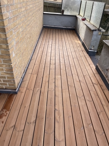 Tømrer udfører tømrerarbejde med montering af altan og terrasse i træ