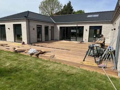 Tømrer udfører tømrerarbejde med renovering af træterrasse ved villa i Vestsjælland