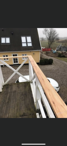 Tømrer udfører tømrerarbejde med montering af altan og gelænder i træ i Vestsjælland