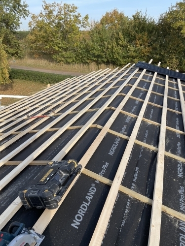 Tømrer udfører tømrerarbejde med opbygning af tag med lægter og undertag