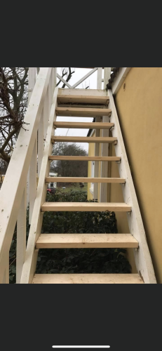 Tømrer udfører tømrerarbejde med opbygning af udvendig trappe i træ